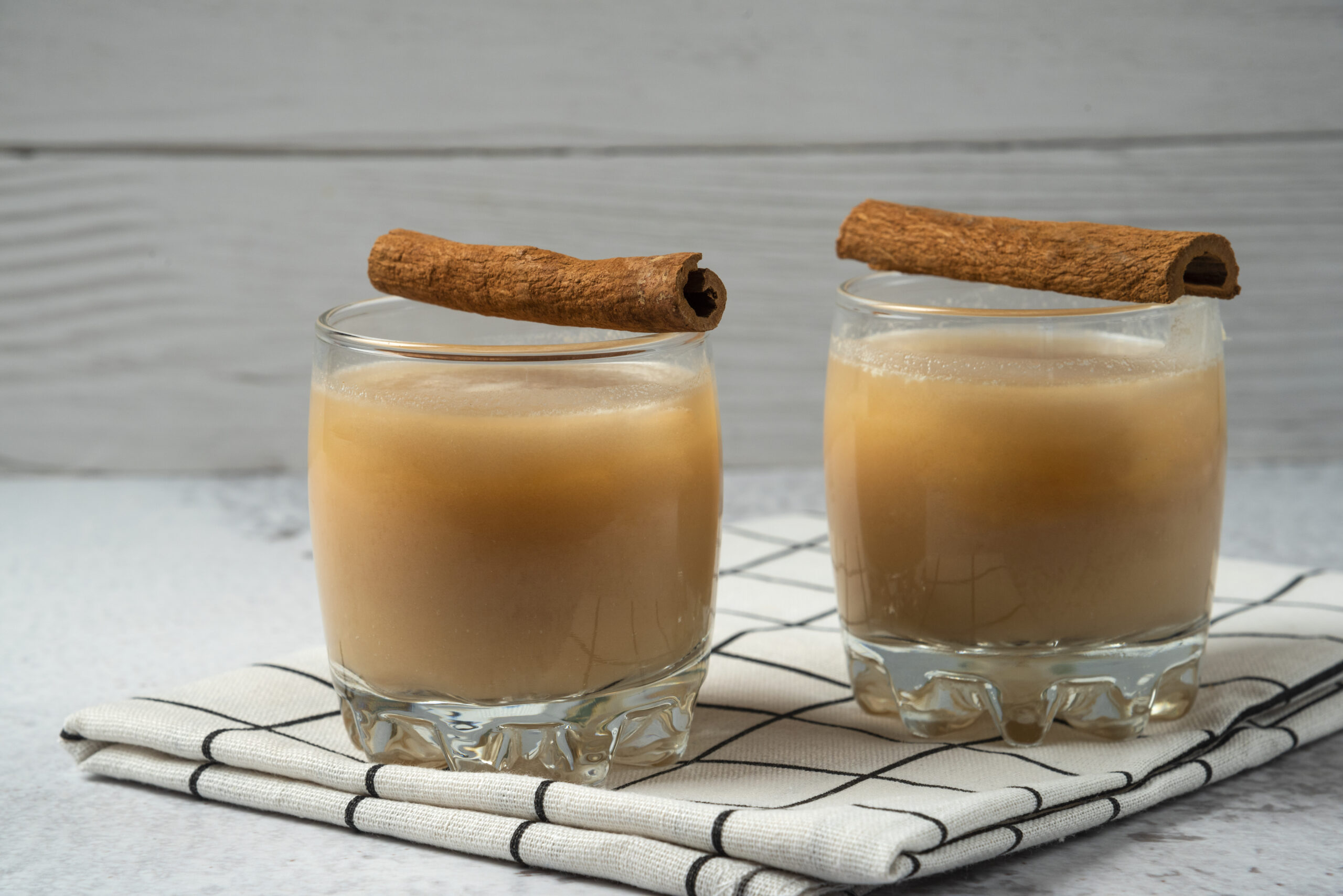 jugo de manzana en la taza con sabor canela en la toalla cuadros